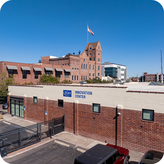 tgh innovation center exterior in ybor city with brick building and parking structure in the background